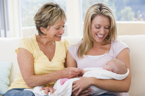 Grandmother and mother in living room with baby smiling