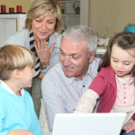 pensioners with grandchildren using computer