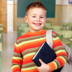 Beautiful child with books and backpack in class