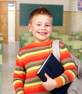 Beautiful child with books and backpack in class