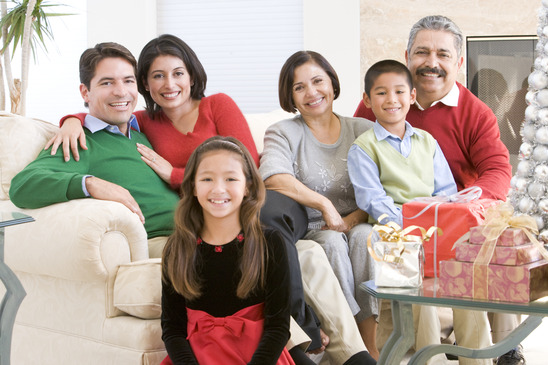 Family Sitting Around A Coffee Table And Christmas Gifts