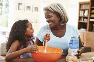 Grandmother And Granddaughter Baking Together At Home