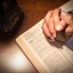 Praying hands on a bible