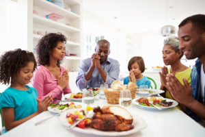 Multi Generation African American Family Praying At Home