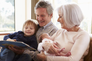 Grandparents With Grandson And Newborn Baby Granddaughter