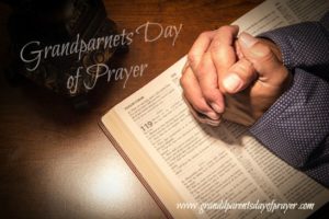 Hands folded in prayer on a Holy Bible.