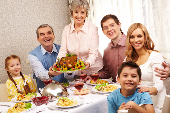 Portrait of big family sitting at festive table and looking at camera with smiles